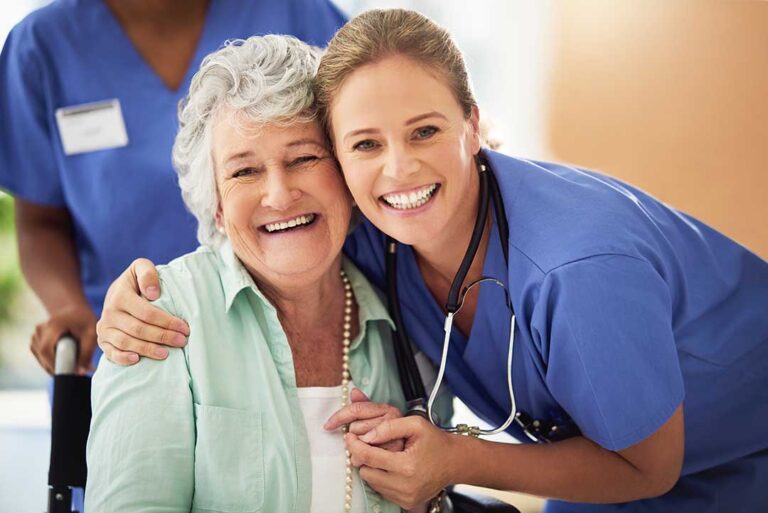 Caregiver calmly helps an older resident with a daily activity in a bright assisted living room.