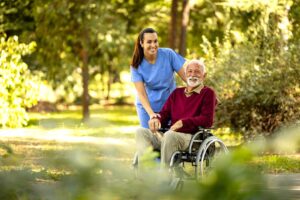 Two older adults having a calm conversation with a staff member in a cozy assisted living common room.